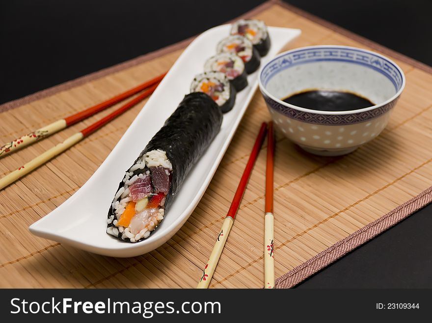 Sushi and soy sauce, with chopsticks, served on table,on dark background. Sushi and soy sauce, with chopsticks, served on table,on dark background