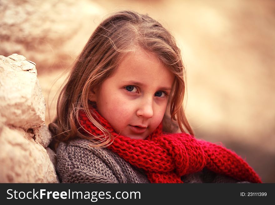 Little sweetie girl child in a red scarf