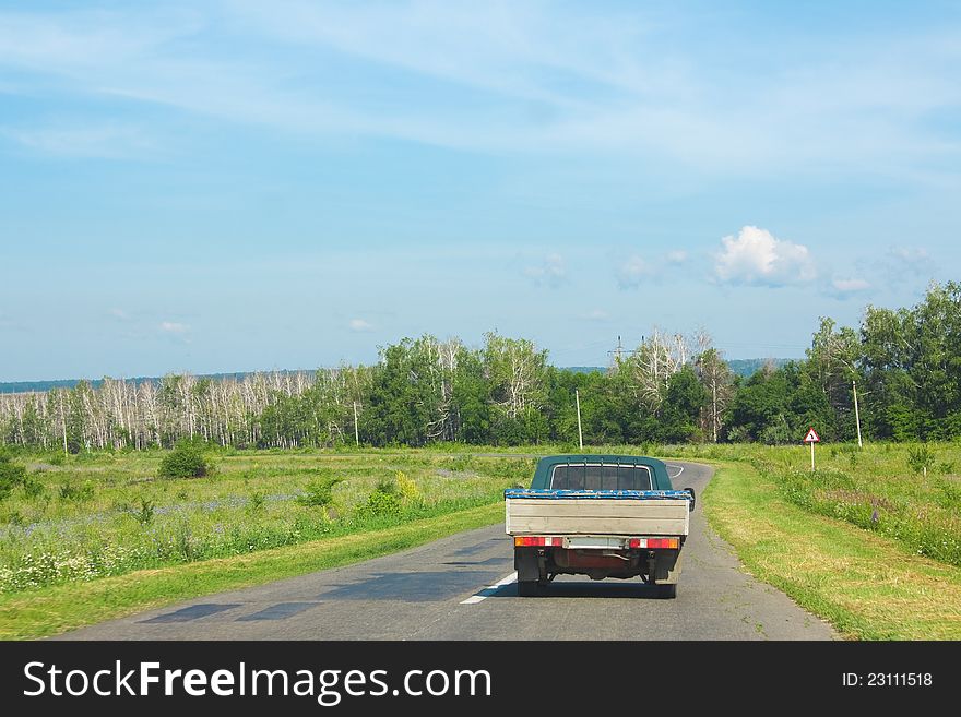 Rural landscape with a road and an old truck. Rural landscape with a road and an old truck