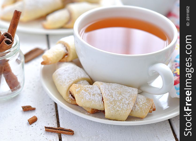 Sweet rolls, cinnamon and a cup of tea on a white table. Sweet rolls, cinnamon and a cup of tea on a white table