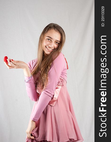 Teenage girl in pink holding plush heart. Teenage girl in pink holding plush heart