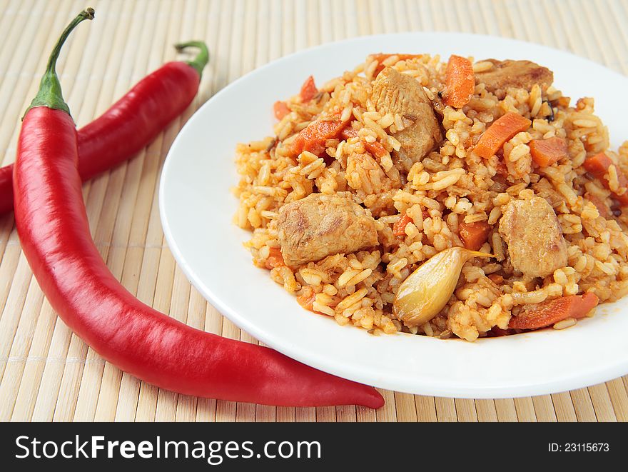 Pilaf with chunks of chicken, carrots and cayenne peppers. Pilaf with chunks of chicken, carrots and cayenne peppers