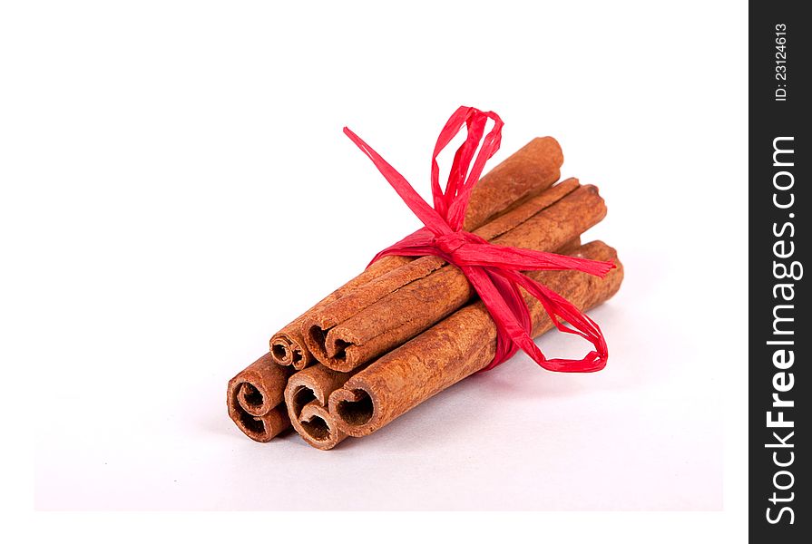 Cinnamon Sticks with red ribbon on white background