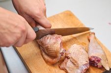 Cutting A Chicken Leg Stock Photo