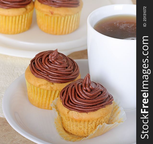 Chocolate frosted cup cakes with a cup of coffee