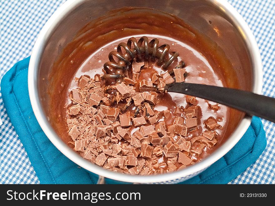 Chef preparing a chocolate sauce by mixing and melting chocolate. Chef preparing a chocolate sauce by mixing and melting chocolate