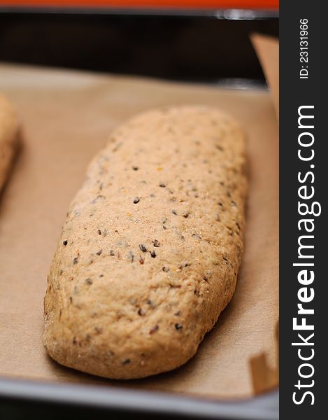 A sweet rye bread loaf rising on a baking paper. A sweet rye bread loaf rising on a baking paper.