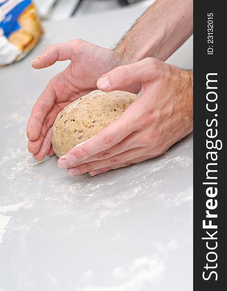 Chef forming a sweet dark bread loaf from dough ball. Chef forming a sweet dark bread loaf from dough ball