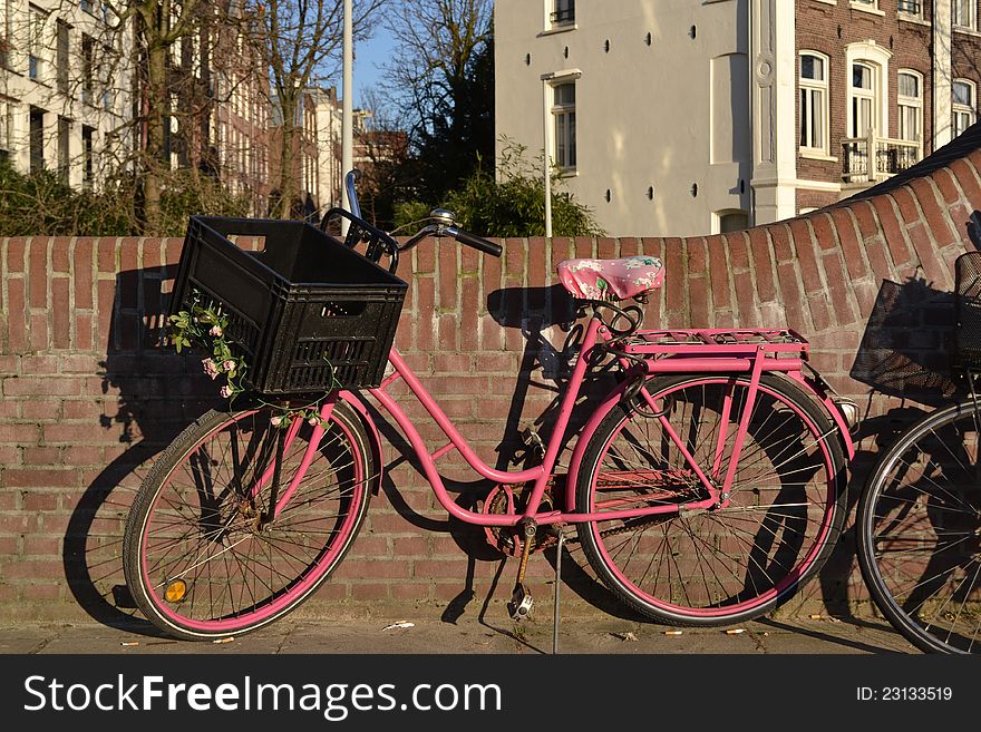 A pink bike in the city of Amsterdam. A pink bike in the city of Amsterdam