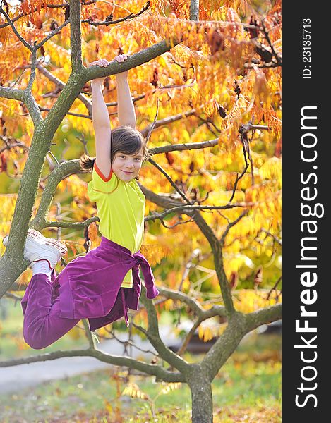 Girl climbed on tree in fall time