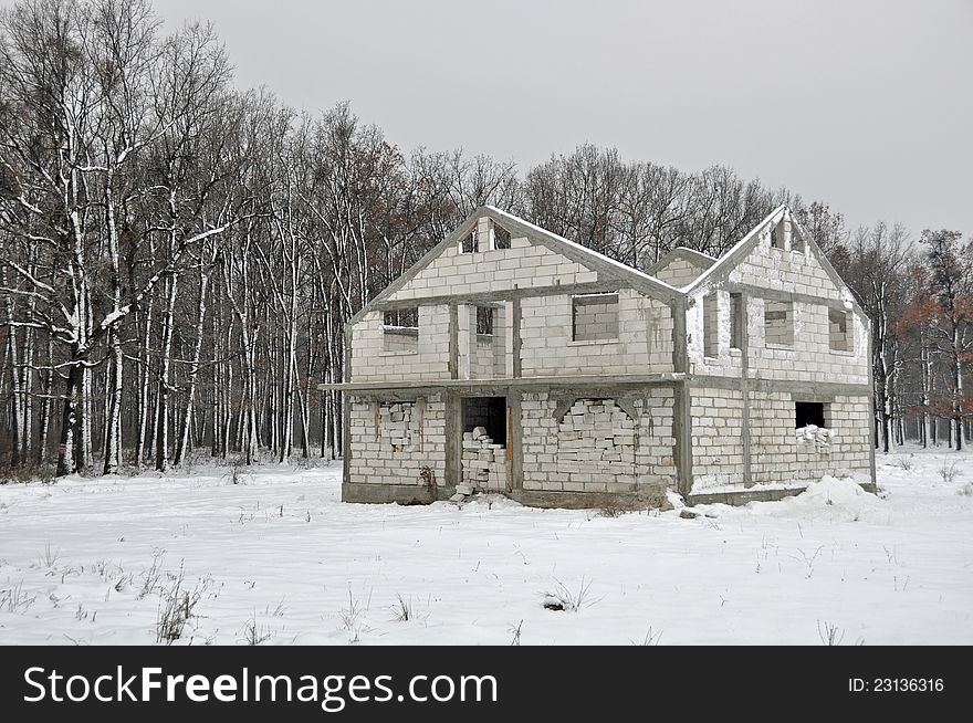 House site in construction near the forest under the snow. House site in construction near the forest under the snow