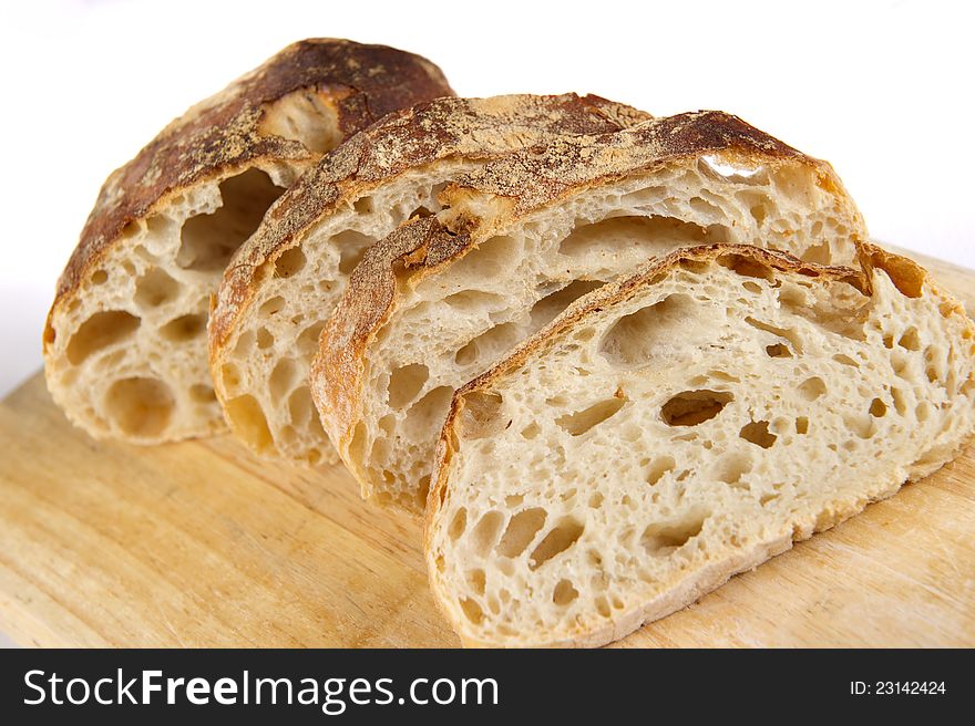 Freshly baked bread sliced on a wooden board. Freshly baked bread sliced on a wooden board.