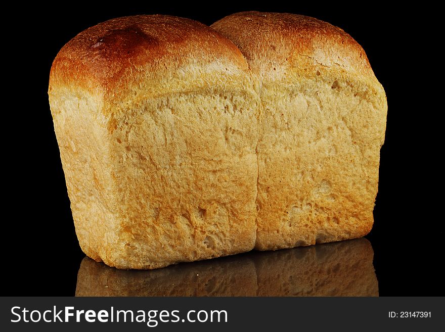 A loaf of bread on a black background. A loaf of bread on a black background.