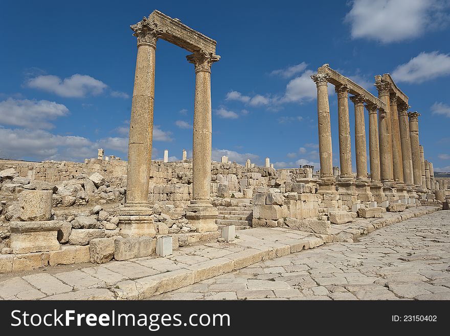 Ancient vertical columns with capital along the Roman road in Jerash, Jordan. Ancient vertical columns with capital along the Roman road in Jerash, Jordan