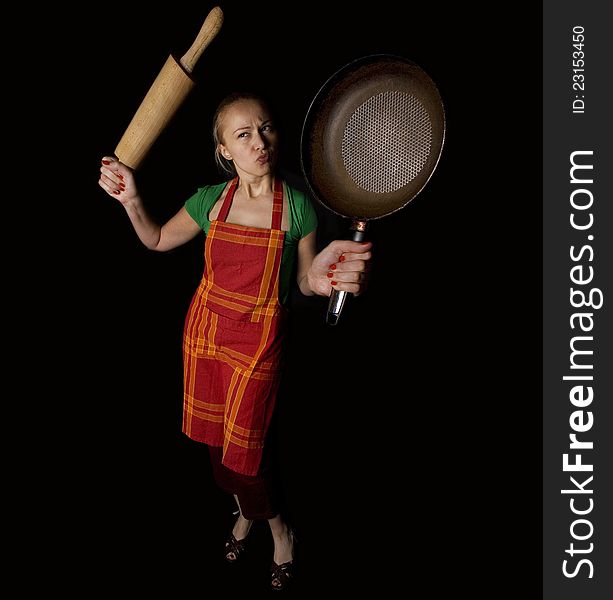Desperate housewife concept - angry female with rolling pin and frying pan in hands