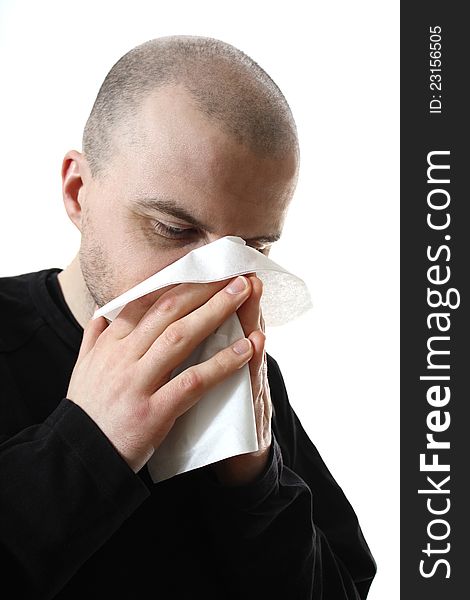 Young caucasian guy blowing nose in tissue. Young caucasian guy blowing nose in tissue