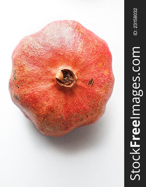 Top view of a ripe pomegranate on grey background
