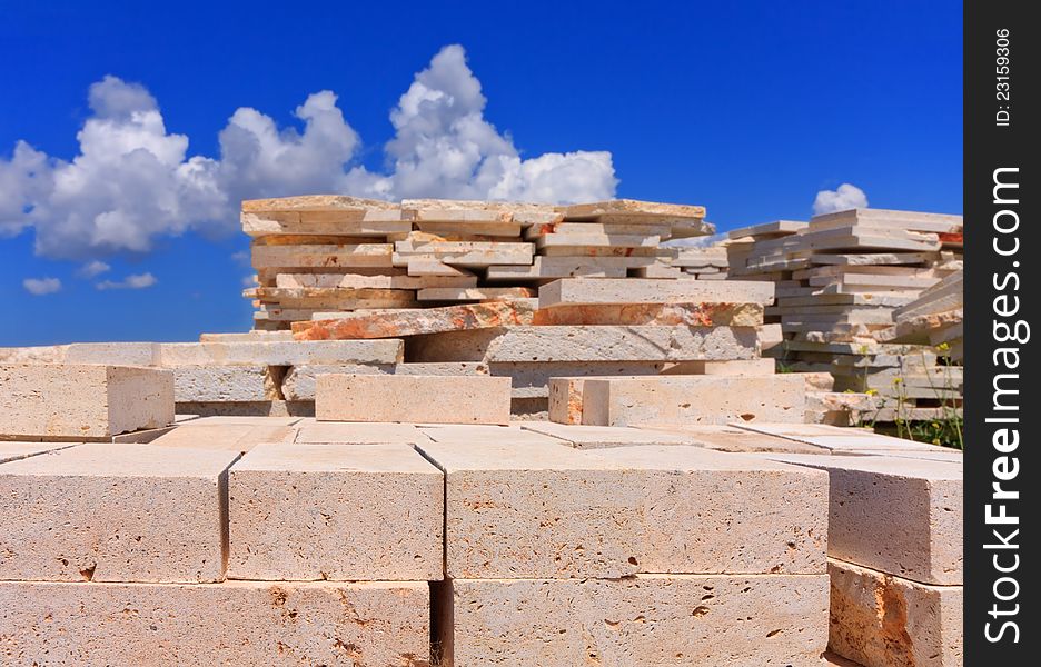 Blocks of limestone processed and ready for use, are against the blue sky. Blocks of limestone processed and ready for use, are against the blue sky