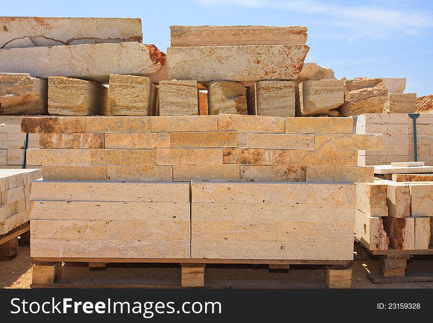 Blocks of limestone processed and ready for use, are against the blue sky. Blocks of limestone processed and ready for use, are against the blue sky