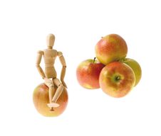 Wooden Model Sits On An Apple Stock Photos