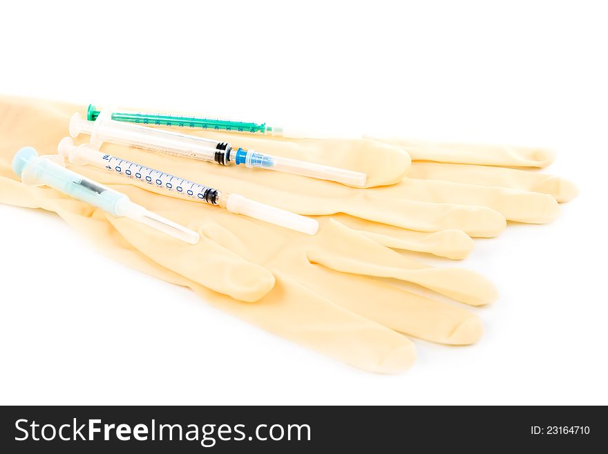 Several syringes and medical gloves on a white background. Several syringes and medical gloves on a white background.