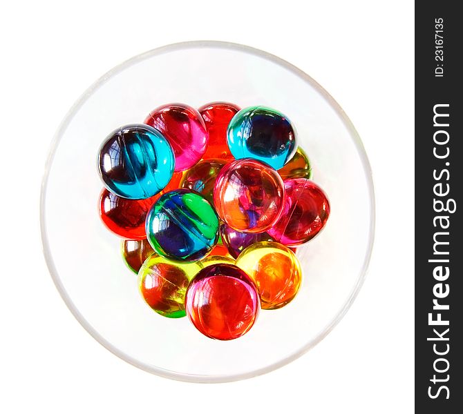 Colourful bath pearls in a glass. Overhead shot. White background. Colourful bath pearls in a glass. Overhead shot. White background.