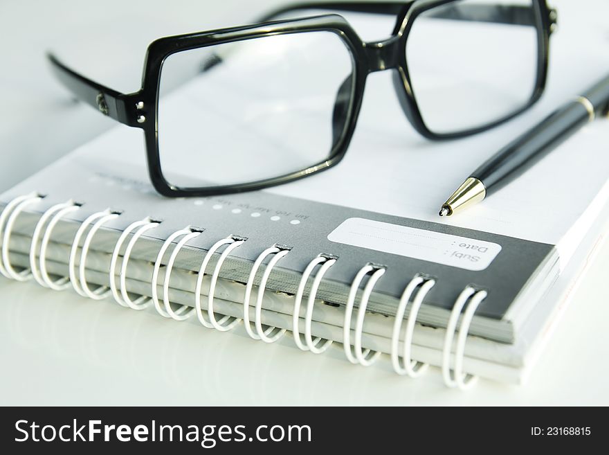 Glasses and a pen on open book. Glasses and a pen on open book