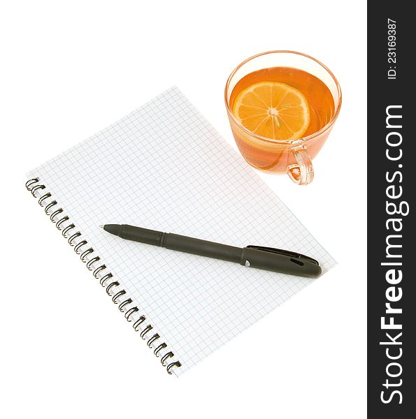 Black pen on a white notebook with a spring and cup I expect with a lemon on a white background. Black pen on a white notebook with a spring and cup I expect with a lemon on a white background