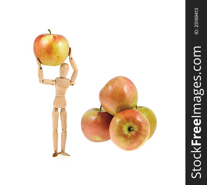 Wooden model holds an apple near the heap of apples on a white background