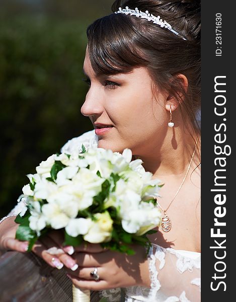 Happy bride with flowers looking sideways