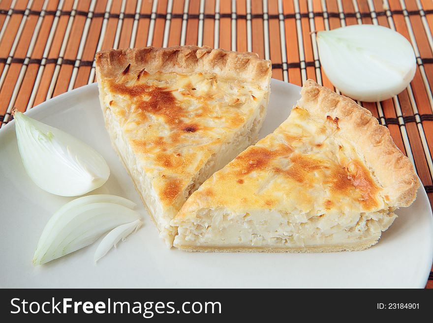 Two pieces of pie with onions on a wooden board