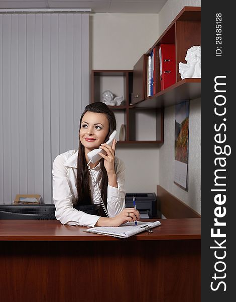 Smiling Businesswoman Talking On Phone And Writing