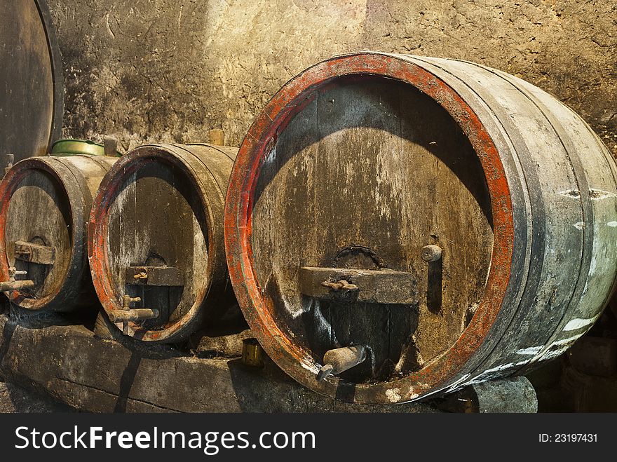 Old wine barrels in a wine cellar with mold and cobwebs. Old wine barrels in a wine cellar with mold and cobwebs