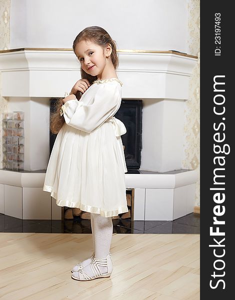 Smiling Girl  White Dress Standing Near Fireplace