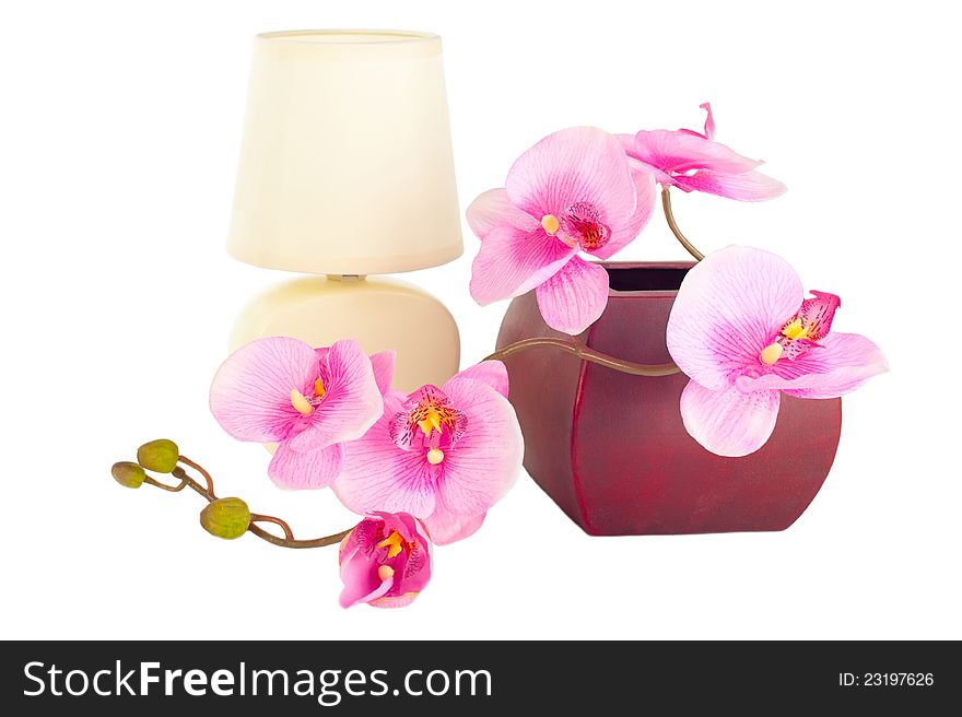 Modern table lamp and branch of artificial orchid flower in pot isolated on white. Modern table lamp and branch of artificial orchid flower in pot isolated on white