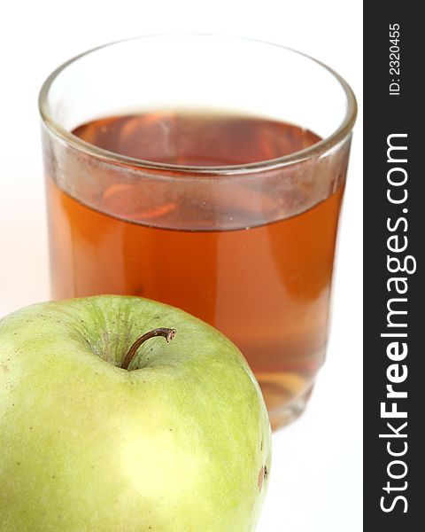 Green apple and glass of juice on a white background