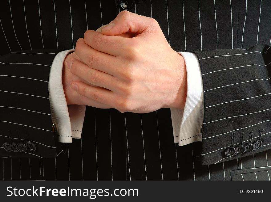 Compressed  hands of  businessman on  background of  black jacket, close up. Compressed  hands of  businessman on  background of  black jacket, close up