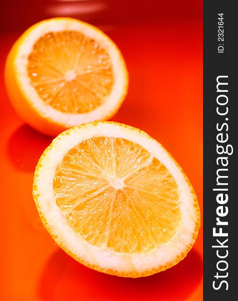 Two slices of  lemon on an orange background, close up. Two slices of  lemon on an orange background, close up