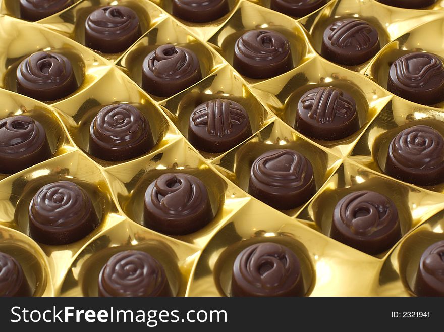 Chocolates in golden packing. Landscape background
