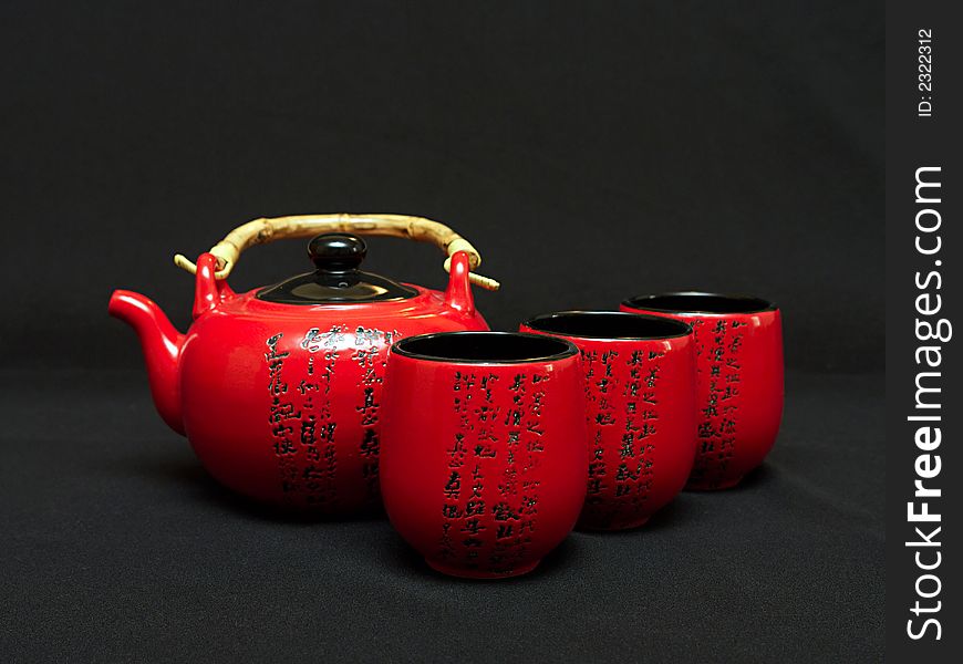 Red Chinese teapot with cups for tea leaves of green tea