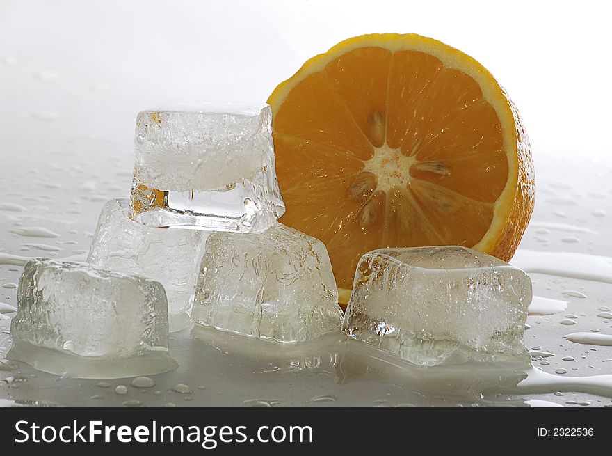 Five ice cubes melted in water and slice of lemon. Five ice cubes melted in water and slice of lemon