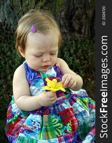 Cute little girl sitting outside with flower. Cute little girl sitting outside with flower