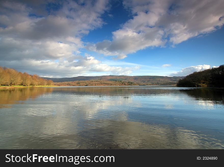 Beautiful shoreline view with sky reflexions in water and spring colors