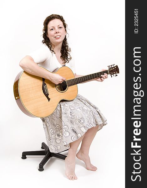 Young woman singing and playing an acoustic guitar. Young woman singing and playing an acoustic guitar