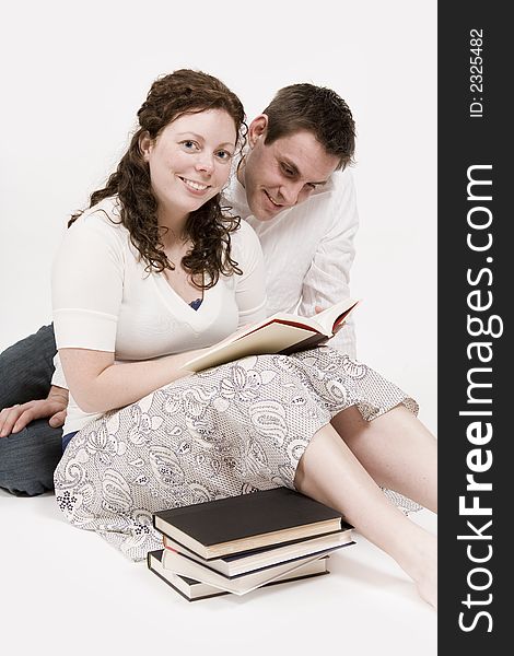 A beautiful young couple a book reading together. A beautiful young couple a book reading together