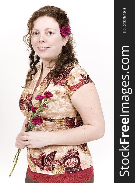 Beautiful young woman poses with red flowers