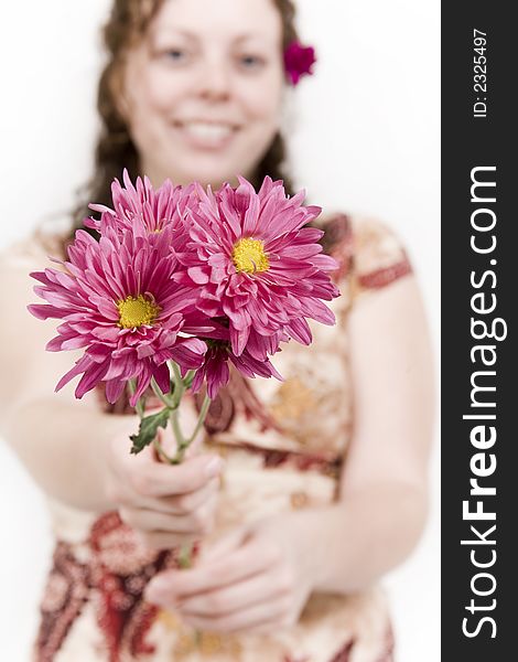 Beautiful young woman poses with red flowers