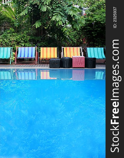 Row of deck chairs by a swimming pool. Row of deck chairs by a swimming pool