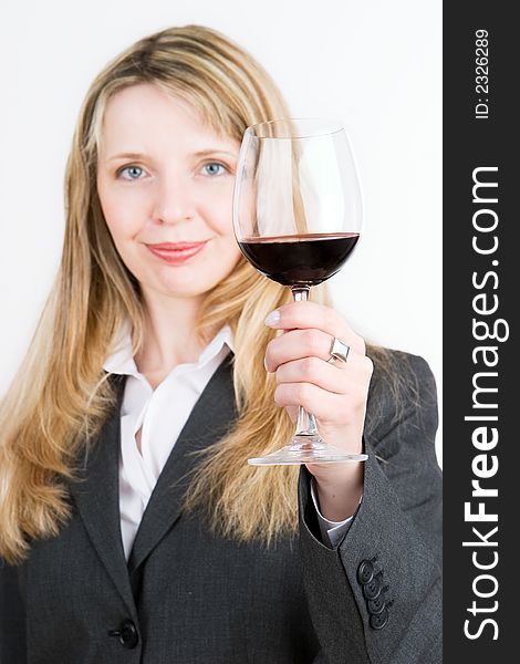A young business woman holding a glass of red wine. Focus on the wine glass. A young business woman holding a glass of red wine. Focus on the wine glass
