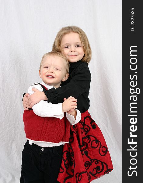 Brother and sister hugging on a white background